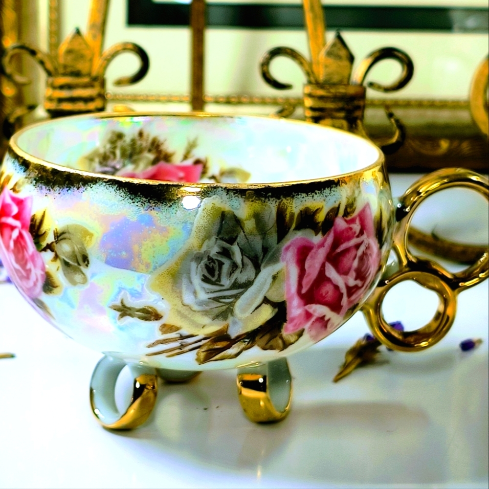 Beautiful three-legged teacup. The pattern consists of large bold roses, brown l